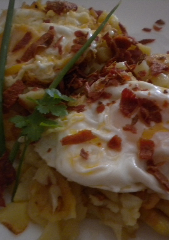 Una foto de Huevos rotos con virutas de jamón