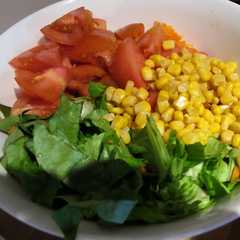 Una foto de Ensalada de lechuga, tomate, zanahorias y choclo