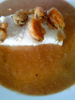 Una foto de Merluza en salsa de cebolla con mejillones en tempura