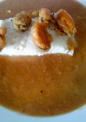 Una foto de Merluza en salsa de cebolla con mejillones en tempura