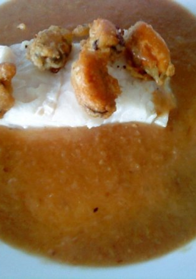 Una foto de Merluza en salsa de cebolla con mejillones en tempura
