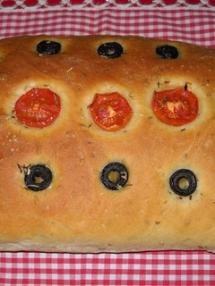 Una foto de Focaccia con aceitunas negras y tomatitos cherry