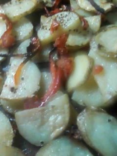 Una foto de Papas rústicas con tomate y aji rojo