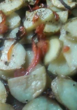 Una foto de Papas rústicas con tomate y aji rojo