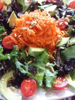 Una foto de Ensalada de lechugas, aguacate y tomates con aliño de piñones