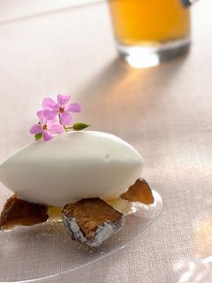 Una foto de Dátil en crudo y en agua con helado de almendra amarga, bomboncitos de naranja y flores de almendra