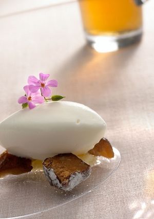 Una foto de Dátil en crudo y en agua con helado de almendra amarga, bomboncitos de naranja y flores de almendra