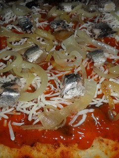 Una foto de Pizza casera con sardinas y cebolla caramelizada