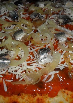 Una foto de Pizza casera con sardinas y cebolla caramelizada