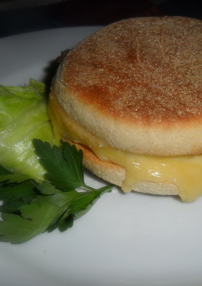 Una foto de English muffin con tortilla, queso y bacon