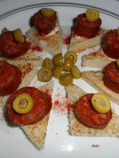 Una foto de Bocaditos con chorizos colorados y olivas rellenas.