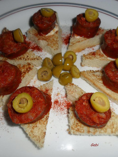 Una foto de Bocaditos con chorizos colorados y olivas rellenas.