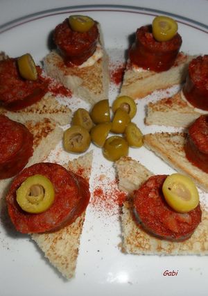 Una foto de Bocaditos con chorizos colorados y olivas rellenas.