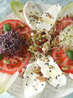 Una foto de Ensalada de tomate y mozzarella con brotes y semillas