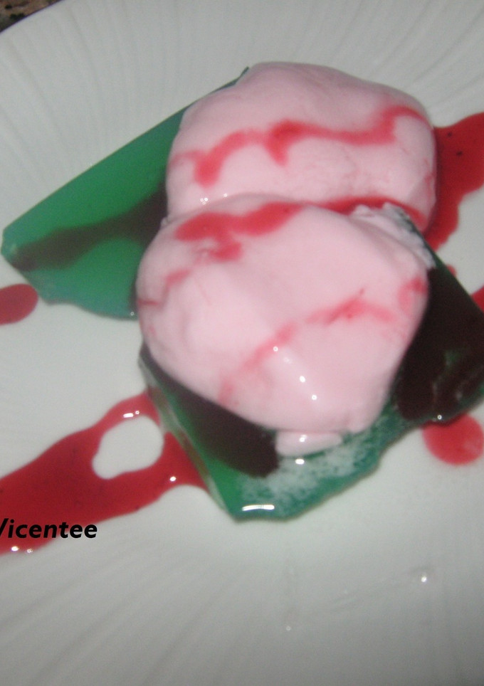 Una foto de Gelatina de manzana verde con esferificacion de yogur de fresa