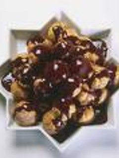 Una foto de Profiteroles con chocolate y nata