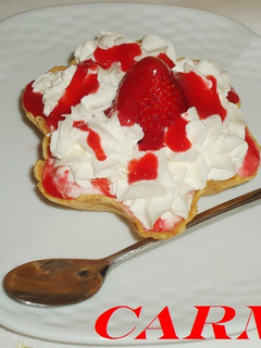 Una foto de Tulipa rellena de salsa de fresas con nata y helado
