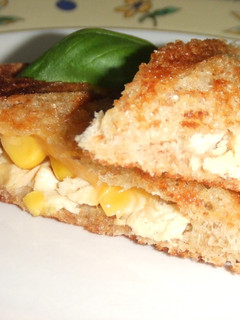Una foto de Sándwich de pollo, maíz y queso