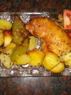 Una foto de Pollo al horno con patatas doradas y pimientos asados