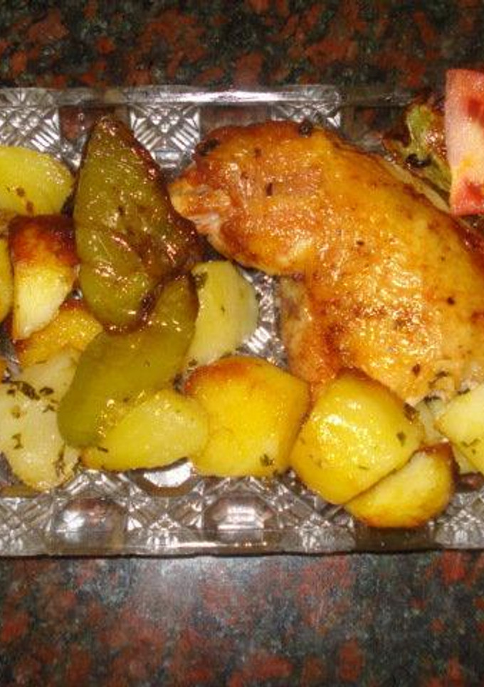 Una foto de Pollo al horno con patatas doradas y pimientos asados