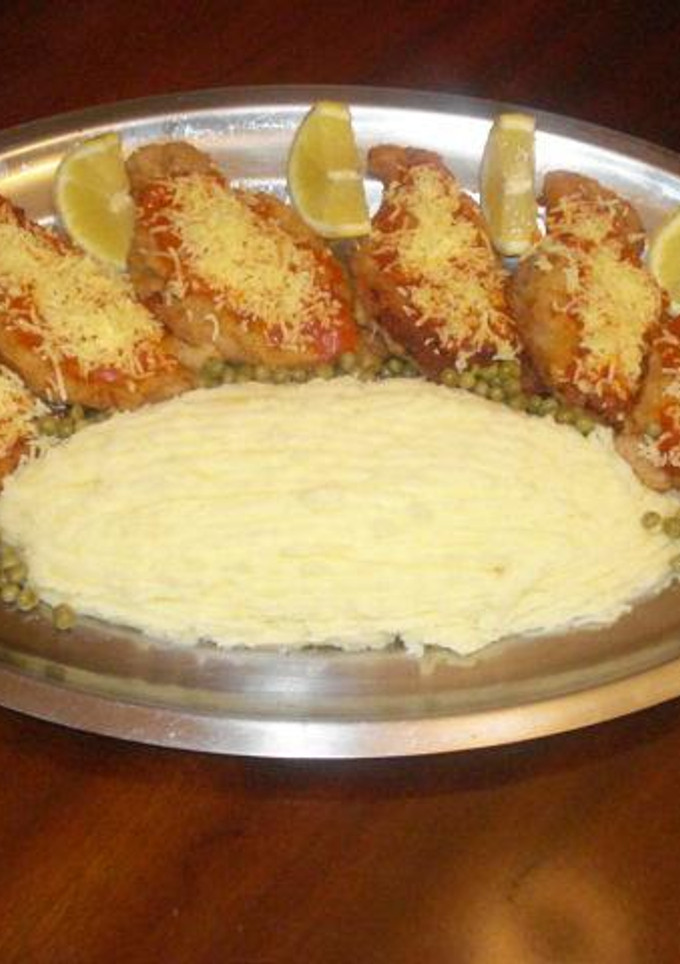 Una foto de Milanesas a la napolitana con puré de patatas y guisantes