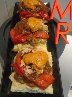 Una foto de Mil hojas de escalivada, cebolla caramelizada, atún y romesco