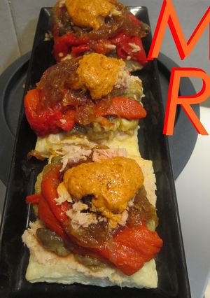 Una foto de Mil hojas de escalivada, cebolla caramelizada, atún y romesco