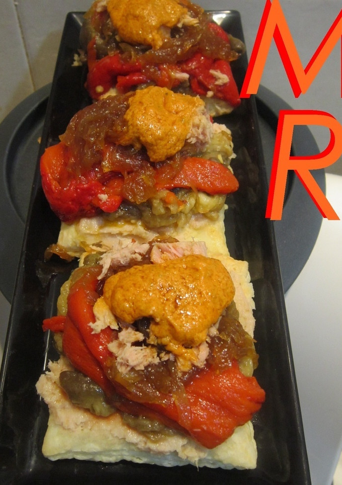 Una foto de Mil hojas de escalivada, cebolla caramelizada, atún y romesco