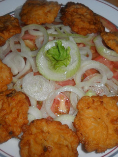 Una foto de Buñuelos de cebolla con ensalada de tomates