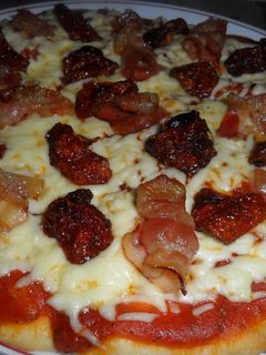 Una foto de Pizza con bacon y tomatitos secos