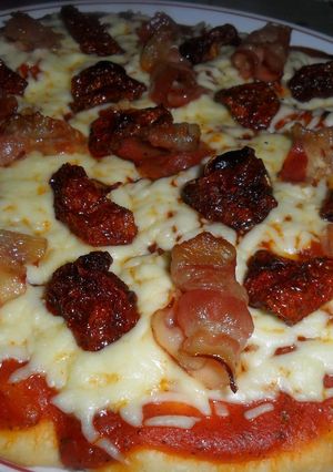 Una foto de Pizza con bacon y tomatitos secos