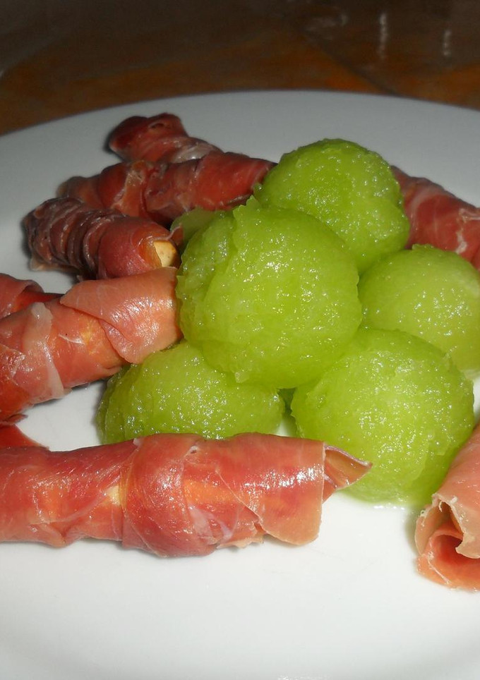 Una foto de Perlas de melón galia con grisines de serrano