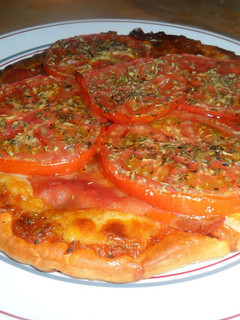 Una foto de Pizza con serrano y tomates al orégano