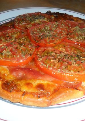 Una foto de Pizza con serrano y tomates al orégano