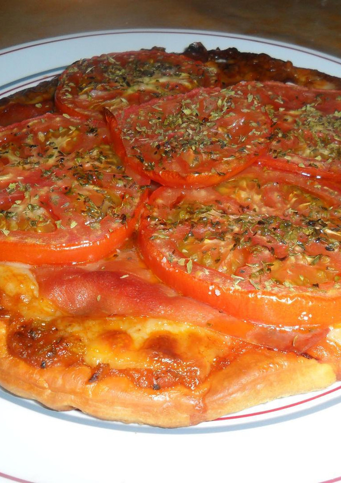 Una foto de Pizza con serrano y tomates al orégano