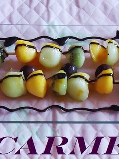 Una foto de Brochetas de frutas y bizcocho con salsa de naranja y chocolate