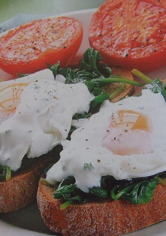 Una foto de Huevos a la plancha y espinacas sobre tostada