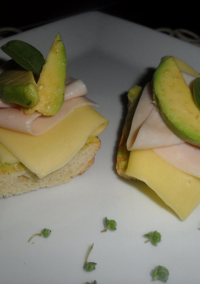 Una foto de Tostadas con pavo, queso y puré de paltas