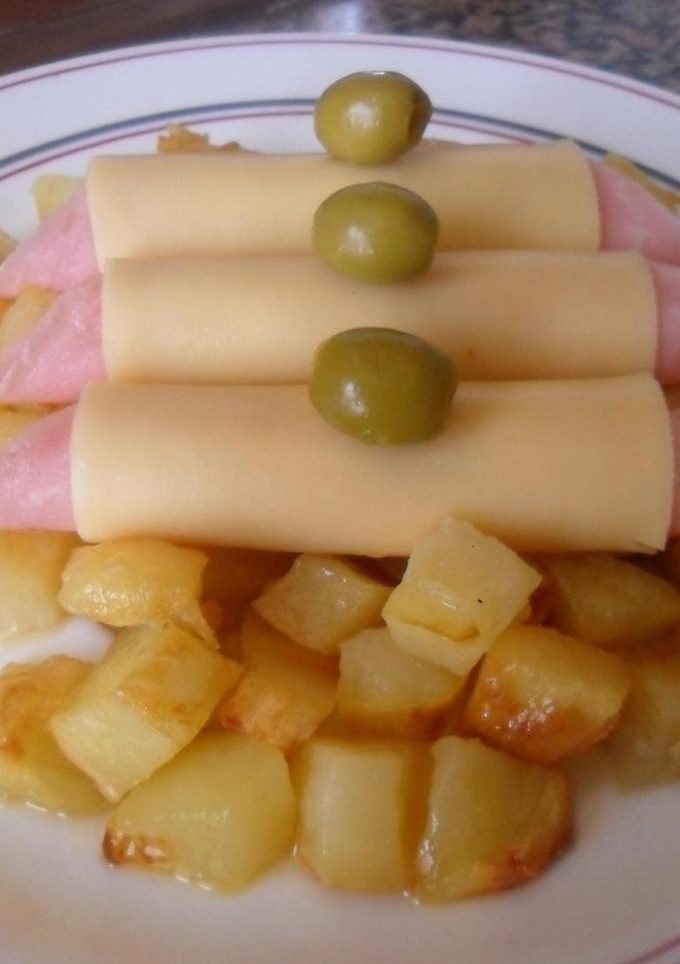 Una foto de Rollitos de jamón y queso sobre dados de patatas al horno