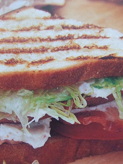 Una foto de Sándwich de pavita con lechuga, bacón y queso