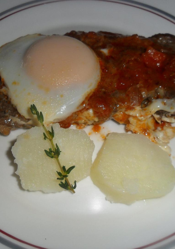 Una foto de Chuletas de cerdo con salsa de tomate y huevos