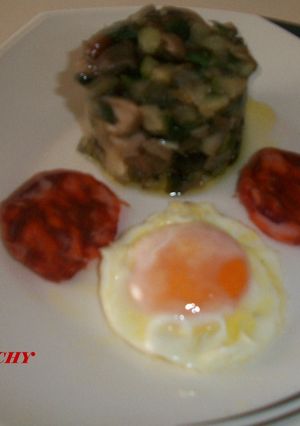 Una foto de Timbal de calabacin con setas, huevo frito y chorizo de Jabugo