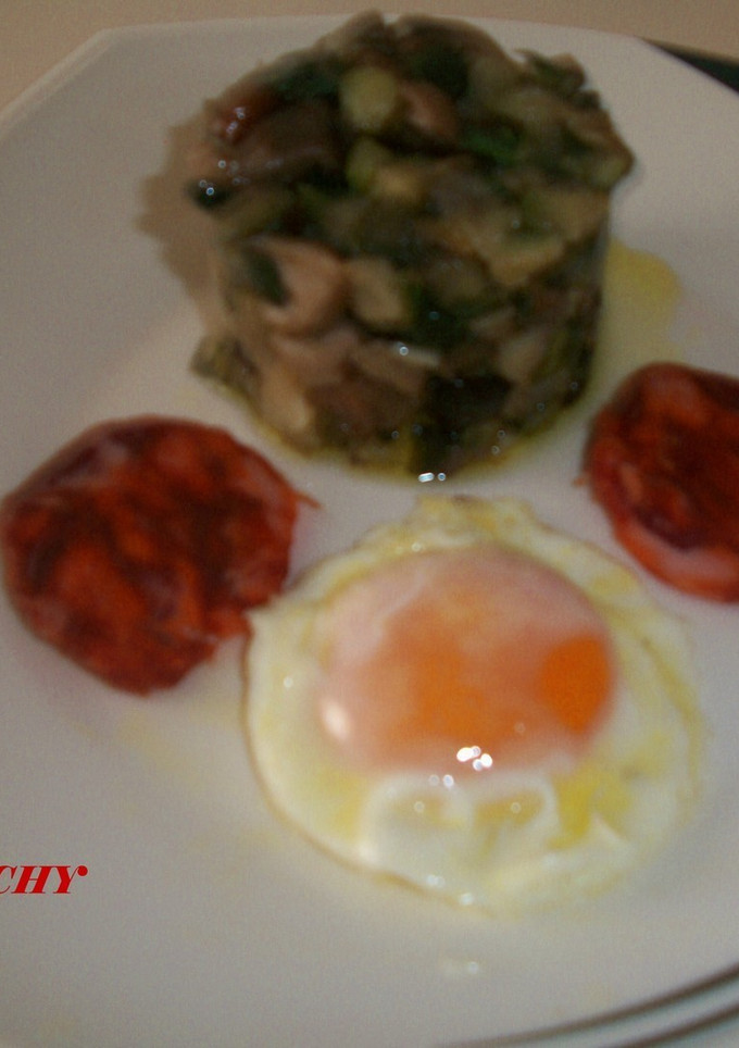 Una foto de Timbal de calabacin con setas, huevo frito y chorizo de Jabugo