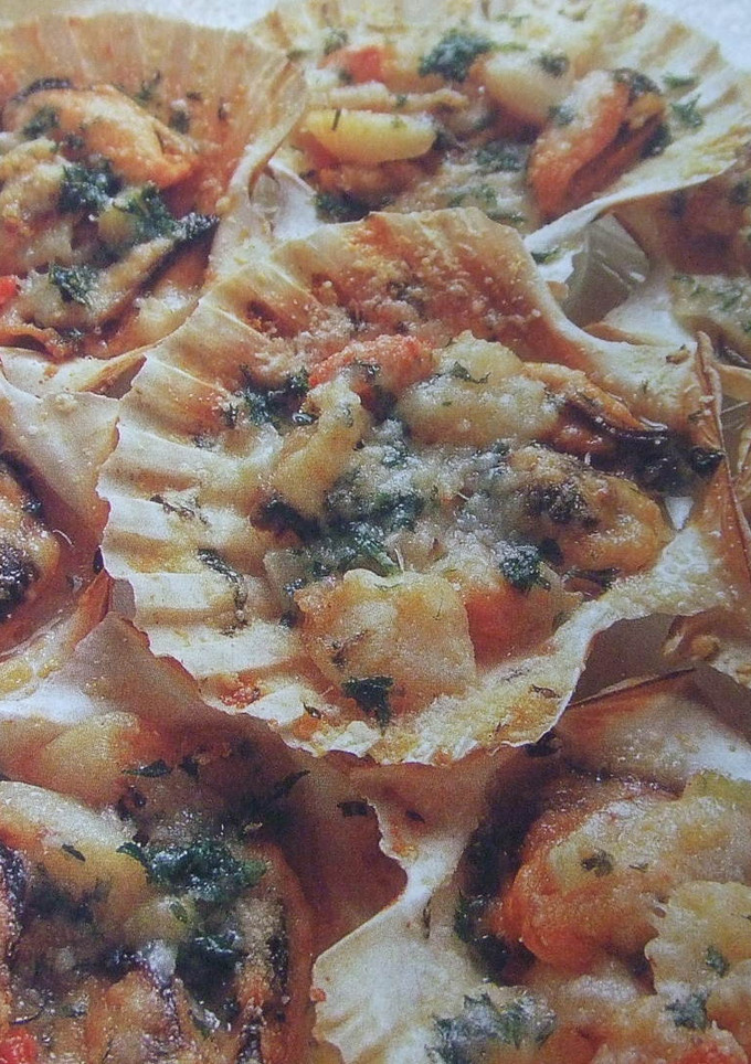 Una foto de Conchas de peregrino gratinadas rellenas de marisco