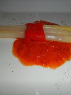 Una foto de Espárragos blancos sobre salsa de morrones