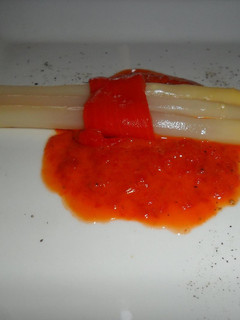 Una foto de Espárragos blancos sobre salsa de morrones