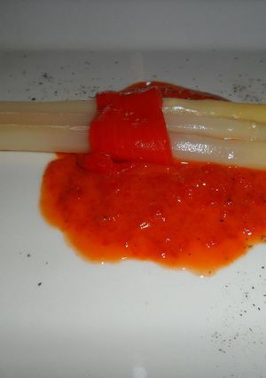 Una foto de Espárragos blancos sobre salsa de morrones