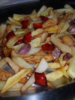 Una foto de Patatas, pimientos y ajos fritos