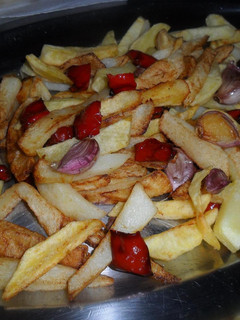 Una foto de Patatas, pimientos y ajos fritos