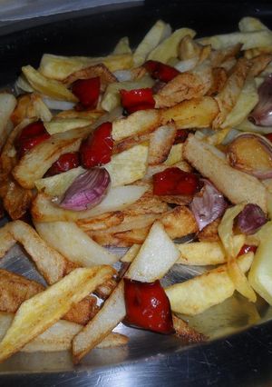 Una foto de Patatas, pimientos y ajos fritos